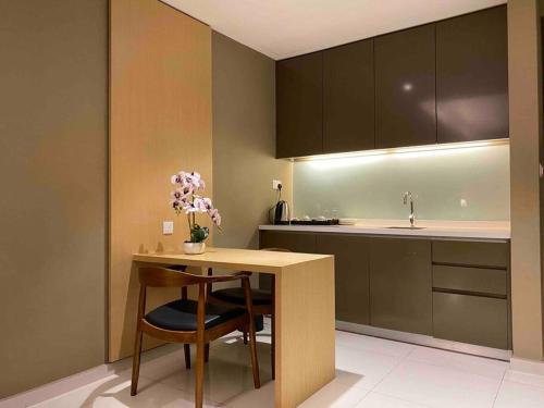 a kitchen with a table with a chair and a sink at D' Pines -Family Suite in Melaka