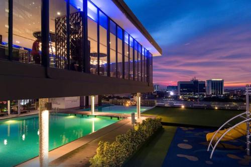 a view of a building with a pool at night at D' Pines -Family Suite in Melaka