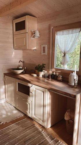 a kitchen with a counter with a sink and a window at Ambercoast in Jūrmala