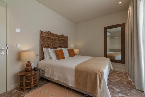 een slaapkamer met een groot bed en een spiegel bij Silves History Guest House in Silves