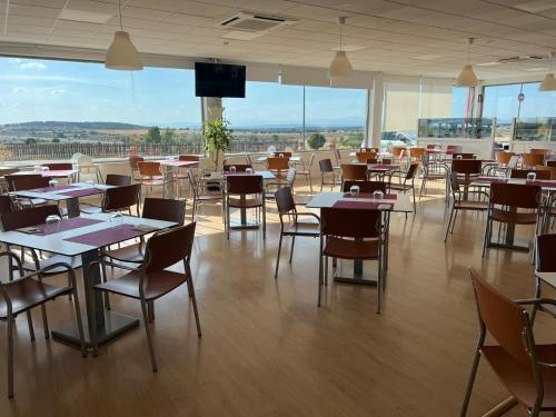 a dining room with tables and chairs and windows at Motel 112 in Algora