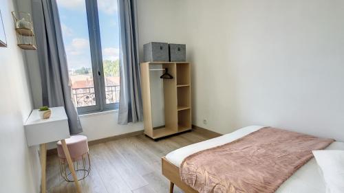 une chambre avec un lit et une grande fenêtre dans l'établissement 15 mn de PARIS, perle rare avec vue - 2 chambres, à Groslay