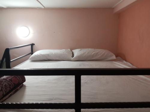 a bed with white sheets and pillows in a room at Hua Tang Homestay in Ipoh