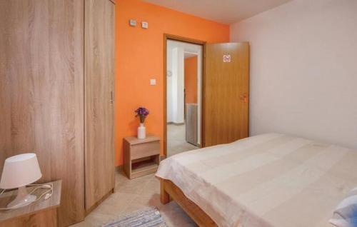 um quarto com uma cama e uma parede laranja em Holiday apartment in Razanj with terrace, air conditioning, WiFi, washing machine 4773-1 em Razanj