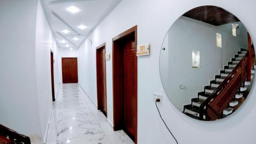 a hallway with a mirror and stairs in a house at The Signature Hotel Multan in Multan