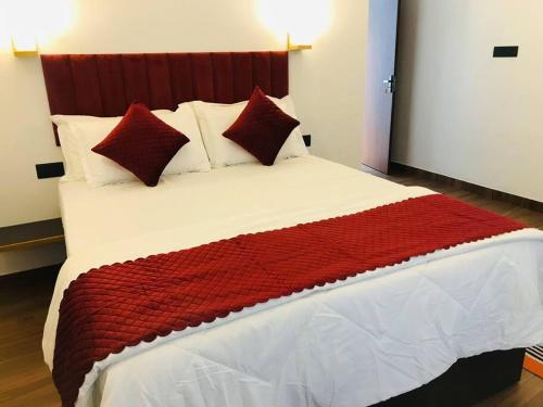 コーチにあるSerendipityのベッドルーム1室(大型ベッド1台、赤と白の枕付)