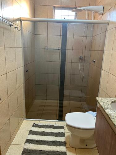 a bathroom with a shower with a toilet and a sink at Madeira Lofts - Suite 01 in Juína