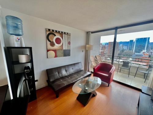 a living room with a couch and a glass table at Gran Terraza con Vista Apoquindo, Apartamento para 4 Personas, Las Condes in Santiago