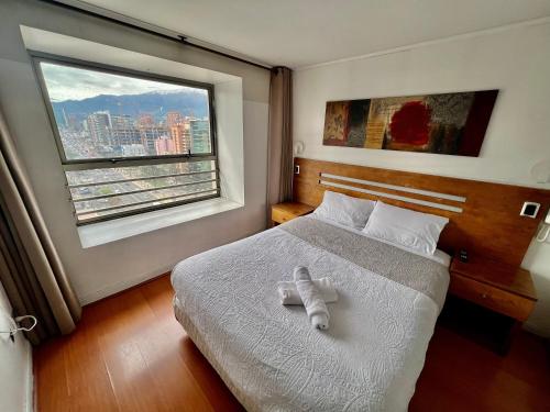 a bedroom with a bed with a white towel on it at Gran Terraza con Vista Apoquindo, Apartamento para 4 Personas, Las Condes in Santiago
