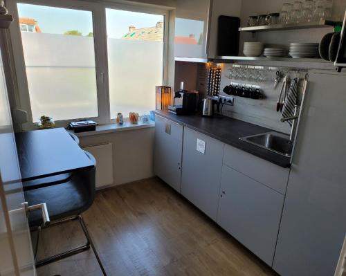 a kitchen with white cabinets and a sink and a window at Bed & Budget123 in Twello