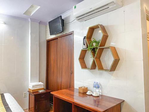 um quarto com uma secretária e uma televisão na parede em My Kim Hotel - Ngay Bến Ninh Kiều em Can Tho