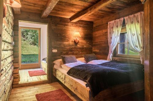 una camera con un letto in una baita di tronchi di Mountain Chalet Obertreyen a Campo Tures