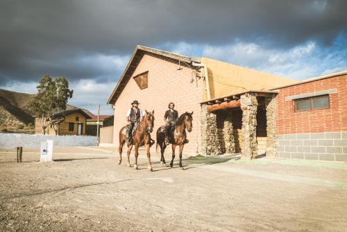 two people riding horses in front of a building at Camping Fort Bravo in Tabernas