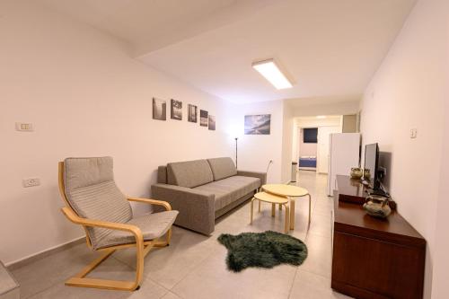 una sala de estar con un sofá y una silla en העוגן והים - The Anchor and the Sea, en Shelomi