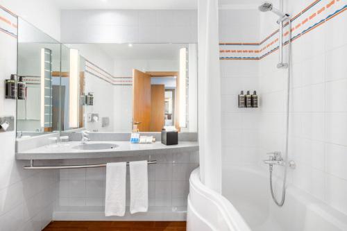 a white bathroom with a sink and a shower at Exe Madrid Norte in Madrid