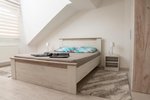een slaapkamer met een groot bed in een witte kamer bij Apartman MENHETN Arandjelovac in Arandjelovac
