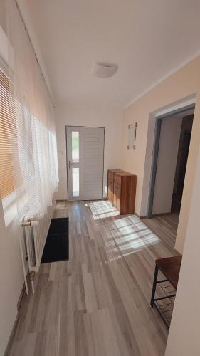 an empty living room with wooden floors and white walls at Apartmán Budín - v klidu přírody, s parkováním in Nové Město nad Metují