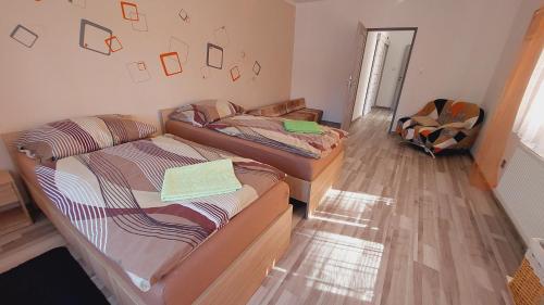 a room with two beds and a couch at Apartmán Budín - v klidu přírody, s parkováním in Nové Město nad Metují