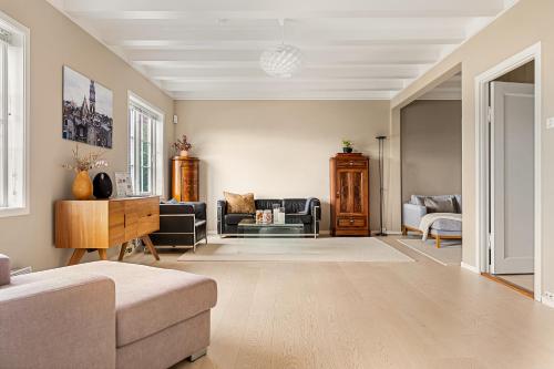 a living room with a couch and a table at Dinbnb Homes I Luxury Villa with Hot Tub & Views in Bergen
