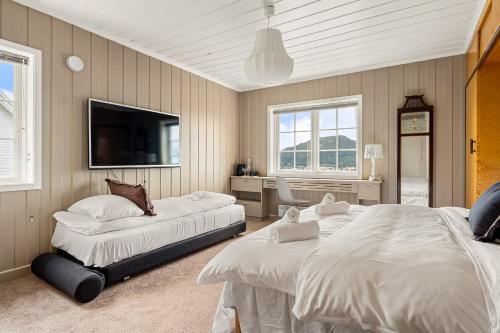una camera con 2 letti e una TV a schermo piatto di Dinbnb Homes I Luxury Villa with Hot Tub & Views a Bergen
