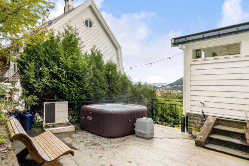 a hot tub sitting on a patio next to a building at Dinbnb Homes I Luxury Villa with Hot Tub & Views in Bergen