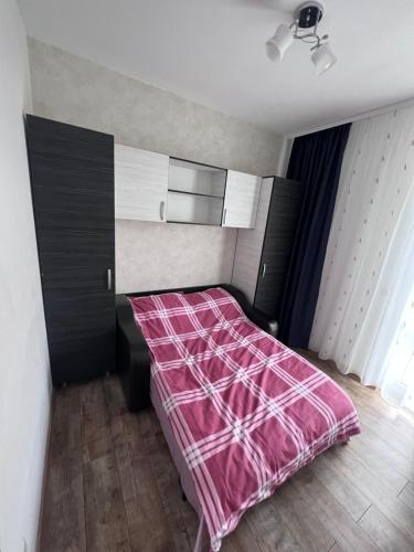 a bedroom with a bed with a pink blanket at Nesta2 in Fălticeni