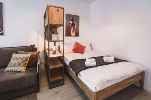 Bearsleys Knights Apartments في ريغا: غرفة نوم صغيرة بسريرين واريكة