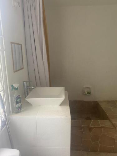 a bathroom with a white sink on top of a cabinet at 3-Bed House in Montego Bay 10 min from airport in Montego Bay