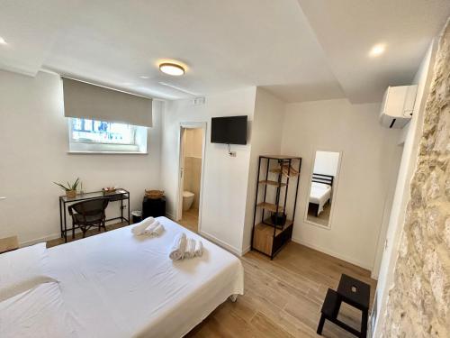 Un dormitorio con una gran cama blanca y una mesa en Sperlonga Sul Mare, en Sperlonga