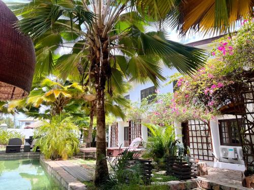 a courtyard with a palm tree and a swimming pool at Olma Colonial Suites in Accra