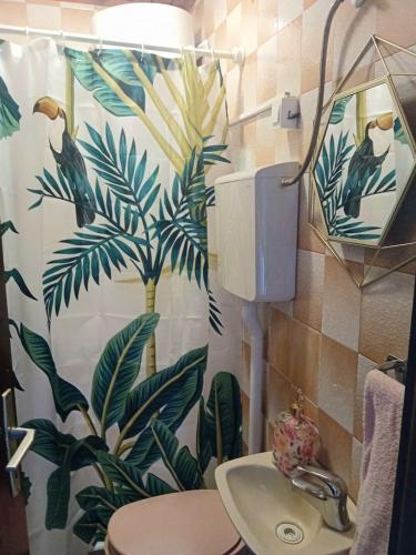 a bathroom with a tropical shower curtain and a sink at Guest House Cinderella in Herceg-Novi
