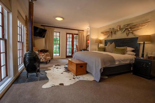 Silvermist Wine Estate في كيب تاون: غرفة نوم بسرير وموقد خشب
