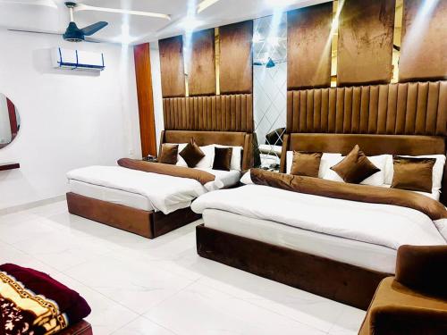 a bedroom with two beds and a couch at The Signature Hotel Multan in Multan