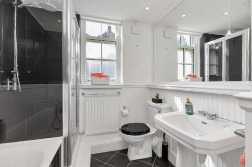 a white bathroom with a toilet and a sink at Entire flat in heart of Chelsea hosted by Zahra in London