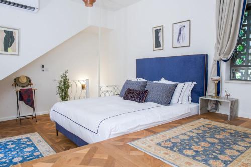 um quarto com uma cama grande e uma cabeceira azul em David Zehavi Apt #2 em Tel Aviv