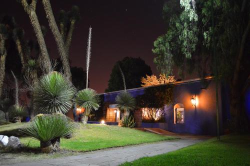 a house at night with palm trees and lights at Villas Arqueologicas Teotihuacan in San Juan Teotihuacán