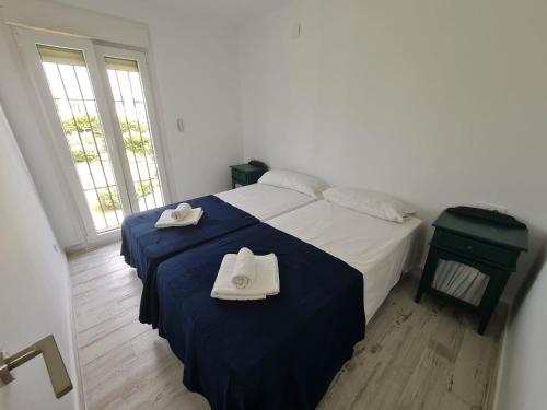 Un dormitorio con una cama con dos toallas encima. en Apartamento 1134, en Zahara de los Atunes