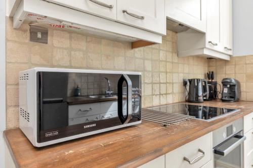a microwave sitting on a counter in a kitchen at Entire flat in heart of Chelsea hosted by Zahra in London