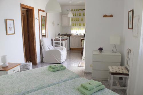 een witte kamer met 2 bedden en een keuken bij Apartamentos Mussa in Valle Gran Rey