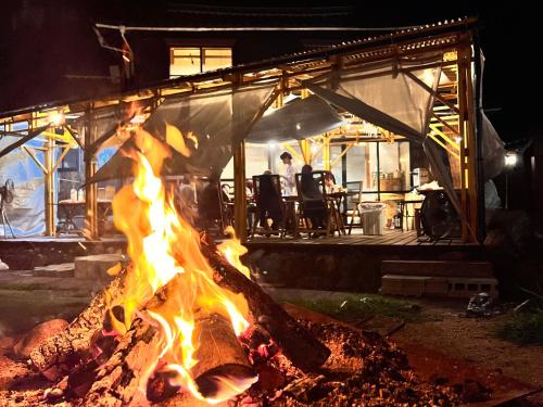 uma fogueira em frente a um restaurante à noite em Fam em Yazu