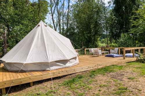 une yourte avec une terrasse en bois et une tente dans l'établissement The Bell Tent - overlooking the moat with decking, à Evesham