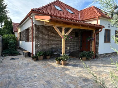 a house with a pavilion with potted plants on a patio at Casa PERLA in Dunajská Streda
