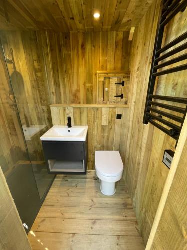La salle de bains en bois est pourvue d'un lavabo et de toilettes. dans l'établissement The Bell Tent - overlooking the moat with decking, à Evesham