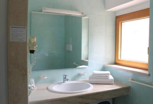 a bathroom with a sink and a mirror at Hotel Villa Campana in Cala Liberotto