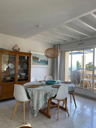une salle à manger avec une table et quelques chaises dans l'établissement Plage de rêve et tennis devant la maison, à Pornichet