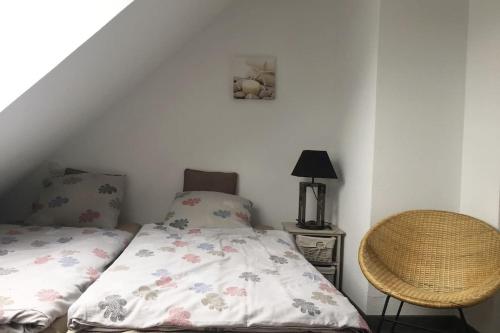 une petite chambre avec un lit et une chaise dans l'établissement Plage de rêve et tennis devant la maison, à Pornichet