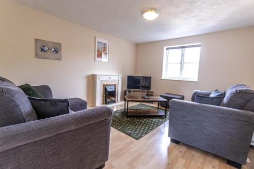 a living room with two couches and a tv at Thorley Court, Swindon in Swindon