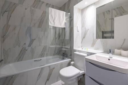 a white bathroom with a toilet and a sink at Stylish East London Flat MS2 in London