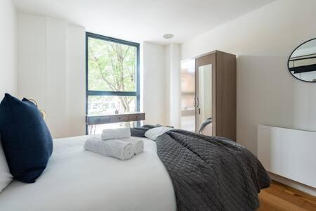 a bedroom with a large white bed with a window at Stylish East London Flat MS2 in London