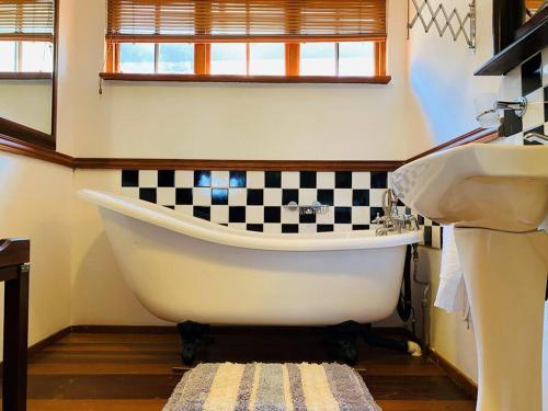 a bathroom with a black and white checkered wall at Brentwood Cottage in Machadodorp